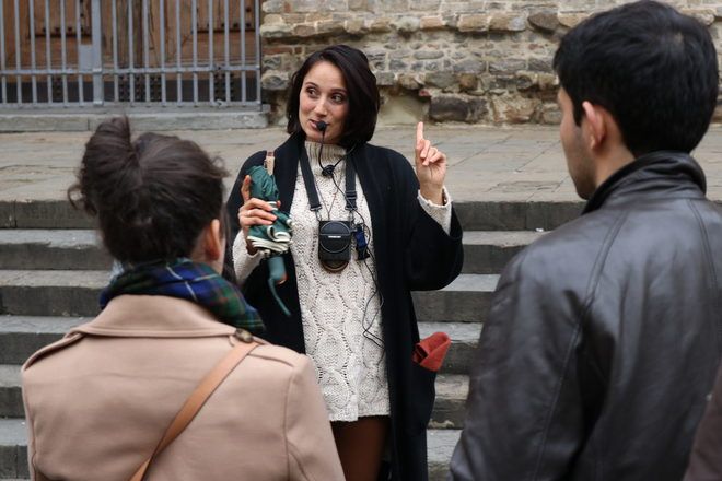 Guía de GuruWalk hablando por un micrófono a sus viajeros en Florencia, Italia.